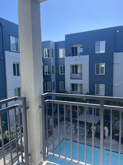 Balcony overlooking a residential courtyard and pool