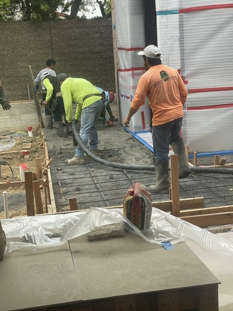 Crew pouring and finishing a concrete foundation