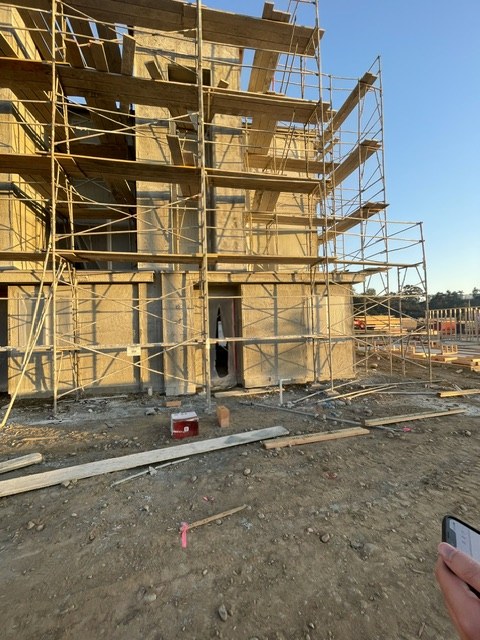 Framed multi-story building with scaffolding