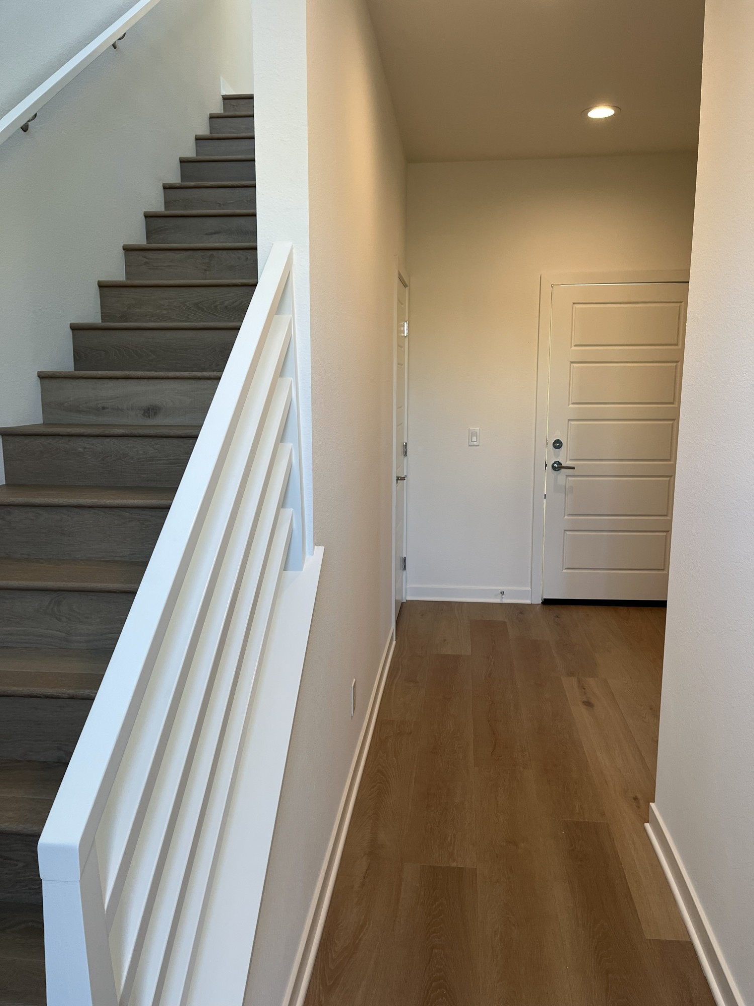 Staircase with white slatted rail and wood-look flooring