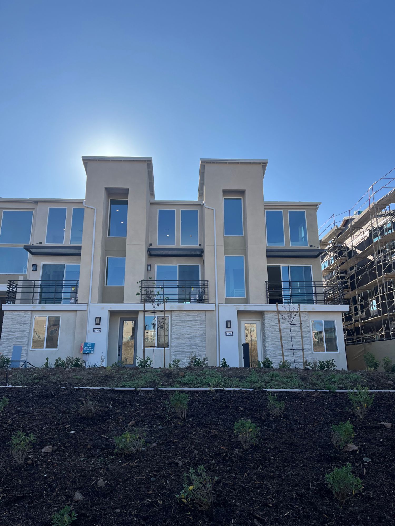 Completed three-story townhomes with balconies and new landscaping